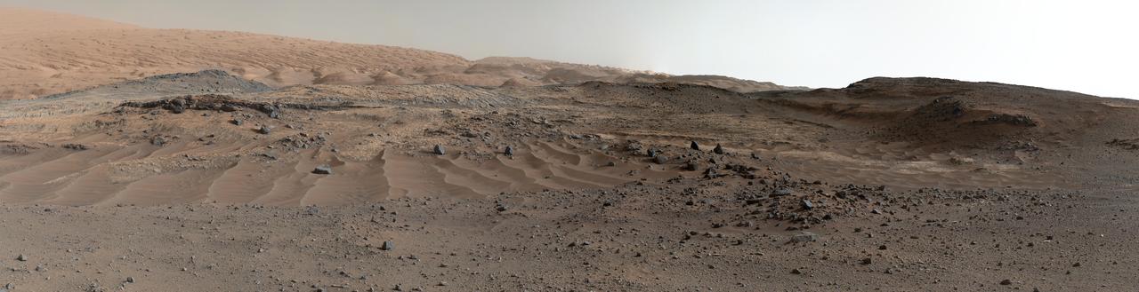 A southward-looking panorama combining images from both cameras of the Mast Camera Mastcam instrument on NASA Curiosity Mars Rover shows diverse geological textures on Mount Sharp.  A southward-looking panorama combining images from both cameras of the Mast Camera (Mastcam) instrument on NASA's Curiosity Mars Rover shows diverse geological textures on Mount Sharp.  Three years after landing on Mars, the mission is investigating this layered mountain for evidence about changes in Martian environmental conditions, from an ancient time when conditions were favorable for microbial life to the much-drier present.  Gravel and sand ripples fill the foreground, typical of terrains that Curiosity traversed to reach Mount Sharp from its landing site. Outcrops in the midfield are of two types: dust-covered, smooth bedrock that forms the base of the mountain, and sandstone ridges that shed boulders as they erode. Rounded buttes in the distance contain sulfate minerals, perhaps indicating a change in the availability of water when they formed. Some of the layering patterns on higher levels of Mount Sharp in the background are tilted at different angles than others, evidence of complicated relationships still to be deciphered.  The scene spans from southeastward at left to southwestward at right. The component images were taken on April 10 and 11, 2015, the 952nd and 953rd Martian days (or sols) since the rover's landing on Mars on Aug. 6, 2012, UTC (Aug. 5, PDT). Images in the central part of the panorama are from Mastcam's right-eye camera, which is equipped with a 100-millimeter-focal-length telephoto lens. Images used in outer portions, including the most distant portions of the mountain in the scene, were taken with Mastcam's left-eye camera, using a wider-angle, 34-millimeter lens.  http://photojournal.jpl.nasa.gov/catalog/PIA19803