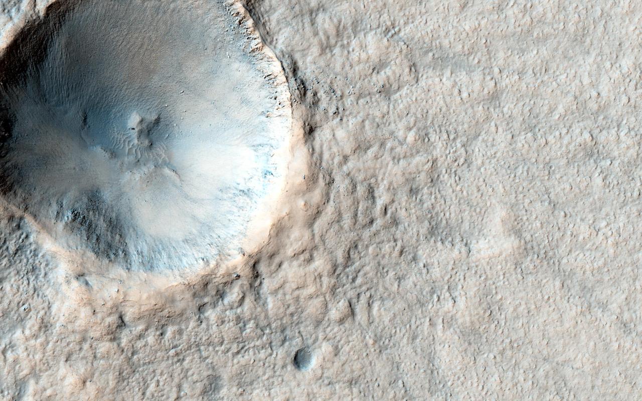 In this image, we see an approximately 500-meter crater that is fairly fresh (in geological terms), but the ejecta is already high-standing. Could this be an indication of early stage of pedestal development?  A pedestal crater is when the ejecta from an impact settles around the new crater and is more erosion-resistant than the surrounding terrain. Over time, the surrounding terrain erodes much faster than the ejecta; in fact, some pedestal craters are measured to be hundreds of meters above the surrounding area.  HiRISE has imaged many other pedestal craters before, and the ejecta isn't always symmetrical, as in this observation.  http://photojournal.jpl.nasa.gov/catalog/PIA19849