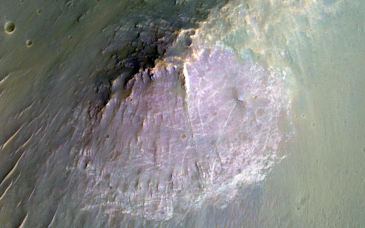 NASA Mars Reconnaissance Orbite observed this image of an isolated mountain in the Southern highlands reveals a large exposure of purplish bedrock.  Since HiRISE color is shifted to longer wavelengths than visible color and given relative stretches, this really means that the bedrock is roughly dark in the broad red bandpass image compared to the blue-green and near-infrared bandpass images.  In the RGB (red-green-blue) color image, which excludes the near-infrared bandpass image, the bedrock appears bluish in color. This small mountain is located near the northeastern rim of the giant Hellas impact basin, and could be impact ejecta.  http://photojournal.jpl.nasa.gov/catalog/PIA19854