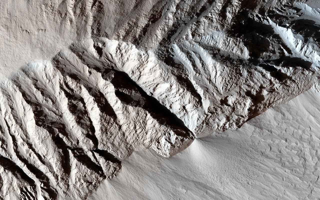 This observation from NASA Mars Reconnaissance Orbiter spacecraft shows a terrain of relatively smooth region that transitions into sharp ridges called yardangs on Apollonaris Patera. These ridges, aligned in the nearly same direction, are called yardangs. Yardangs are not unique to Mars. Many yardangs can be found on Earth, in very dry regions with strong prevailing winds. Yardangs are formed when a surface that is composed of materials of differing strengths (i.e., of both harder and softer materials) is shaped by the abrasive action of sand and dust carried by the wind. In this case, and given the proximity of the Apollonaris Patera volcanic center, we think that these wind-carved deposits are comprised of volcanic ash and pyroclastics that erupted from Apollonaris when it was last active in the not-too-distant geologic past. Over time, the softer materials (likely volcanic ash) were eroded away, leaving behind the harder materials in the form of elongated ridges that are parallel to the direction of the prevailing wind. The end result is a stunning, out-of-this-world display of yardangs, sculpted with the artistic chisel of the Martian wind. http://photojournal.jpl.nasa.gov/catalog/PIA19869