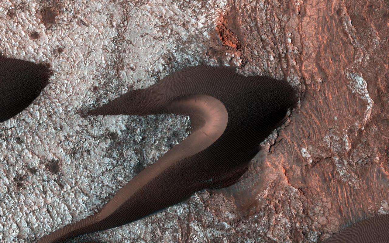 This image from NASA Mars Reconnaissance Orbiter spacecraft provides information about erosion and movement of surface material, about wind and weather patterns, even about the soil grains and grain sizes. However, looking past the dunes, these images also reveal the nature of the substrate beneath. Within the spaces between the dunes, a resistant and highly fractured surface is revealed. The fractured ground is resistant to erosion by the wind, and suggests the material is bedrock that is now shattered by a history of bending stresses or temperature changes, such as cooling, for example. Alternately, the surface may be a sedimentary layer that was once wet and shrunk and fractured as it dried, like gigantic mud cracks. In either case, the relative small and indistinct fractures have trapped the dark dune sand marching overhead. Now the fractures have become quite distinct, allowing us to examine the orientation and spacing of the fractures to learn more about the processes that formed them. http://photojournal.jpl.nasa.gov/catalog/PIA19958