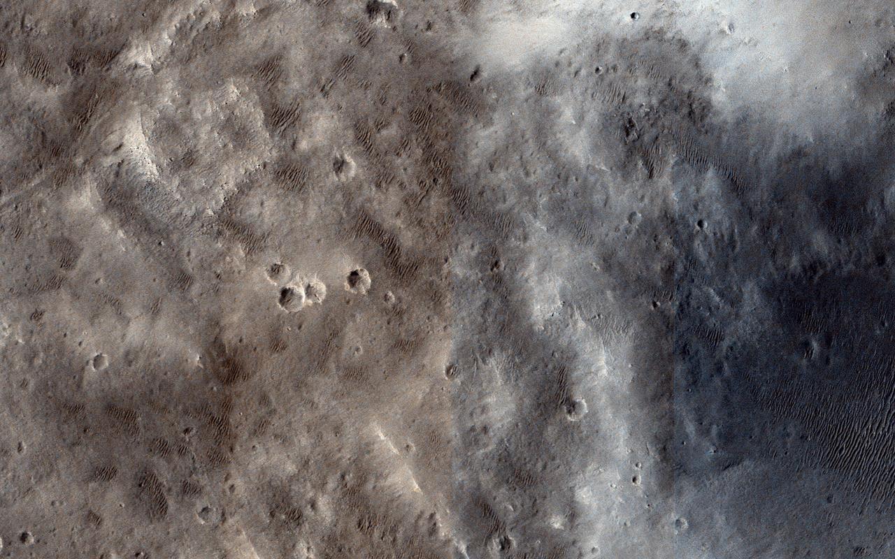 This image from NASA Mars Reconnaissance Orbiter spacecraft shows the nature of the terrain at the rim of Marth Crater.  In the book "The Martian" by Andy Weir, stranded astronaut Mark Watney is headed for the Ares 4 landing site but encounters the rim of Marth Crater just as a dust storm arrives. This HiRISE image shows the nature of this terrain.  The crater rim is not very distinct and from the ground it would be quite difficult to tell that you are even on the rim of a crater. The terrain is hummocky and rolling, punctuated by smaller impact craters and wind-blown drifts of sand or dust.  http://photojournal.jpl.nasa.gov/catalog/PIA19959