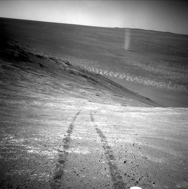 From its perch high on a ridge, NASA Mars Exploration Rover Opportunity recorded this image of a Martian dust devil twisting through the valley below.