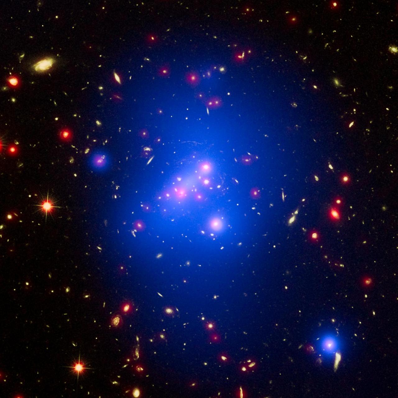 Astronomers have made the most detailed study yet of an extremely massive young galaxy cluster using three of NASA's Great Observatories. This multi-wavelength image shows this galaxy cluster, called IDCS J1426.5+3508 (IDCS 1426 for short), in X-rays recorded by the Chandra X-ray Observatory in blue, visible light observed by the Hubble Space Telescope in green, and infrared light detected by the Spitzer Space Telescope in red.  This rare galaxy cluster, which is located 10 billion light-years from Earth, is almost as massive as 500 trillion suns. This object has important implications for understanding how such megastructures formed and evolved early in the universe. The light astronomers observed from IDCS 1426 began its journey to Earth when the universe was less than a third of its current age. It is the most massive galaxy cluster detected at such an early time.  First discovered by the Spitzer Space Telescope in 2012, IDCS 1426 was then observed using the Hubble Space Telescope and the Keck Observatory to determine its distance. Observations from the Combined Array for Millimeter-wave Astronomy indicated it was extremely massive. New data from the Chandra X-ray Observatory confirm the galaxy cluster's mass and show that about 90 percent of this mass is in the form of dark matter -- the mysterious substance that has so far been detected only through its gravitational pull on normal matter composed of atoms. http://photojournal.jpl.nasa.gov/catalog/PIA20063