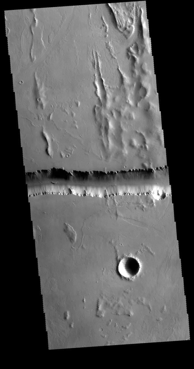 This image captured by NASA 2001 Mars Odyssey spacecraft shows a small portion of Olympica Fossae. Olympica Fossae is located on volcanic plains between Alba Mons and Olympus Mons. The linear margins and uniform width are controlled by faulting; this feature is called a graben. Orbit Number: 61317 Latitude: 26.0058 Longitude: 248.318 Instrument: VIS Captured: 2015-10-10 14:31 http://photojournal.jpl.nasa.gov/catalog/PIA20113