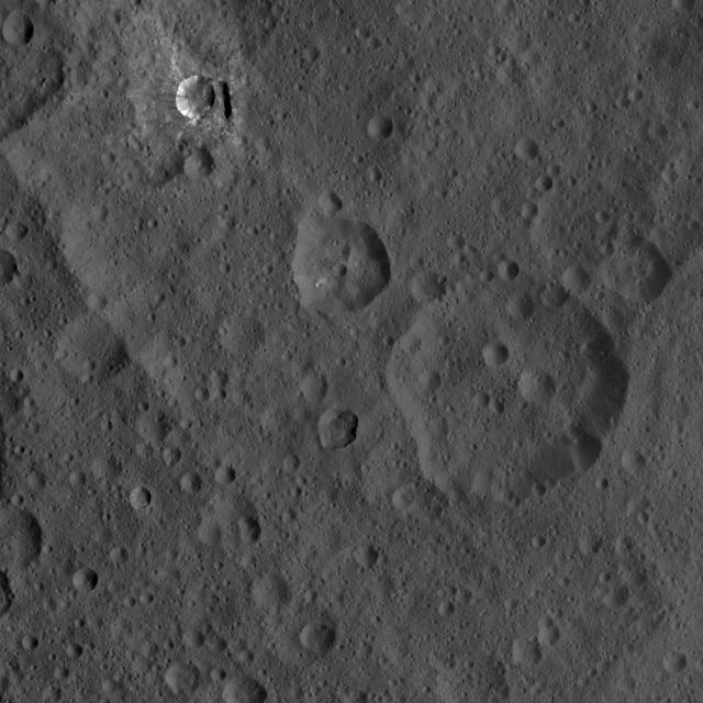 This image of Ceres, taken by NASA's Dawn spacecraft, shows three prominent craters located to the northeast of a terrace (the terrace feature being located at left in this image). The lower two craters, which are larger, have polygonal rims. The steep crater walls, distinct rim and visible ejecta of the upper smaller crater, called Oxo, hint at a fresh impact. Oxo is about 6 miles (9 kilometers) in diameter. Another interesting feature in this view is a short, linear slump, where a mass of material has dropped below the surface, to the east (or right in this view) of Oxo. The image was taken on Oct. 8, 2015, from an altitude of 915 miles (1,470 kilometers), and has a resolution of 450 feet (140 meters) per pixel. The image is located at 42 degrees north latitude, 358 degrees east longitude. http://photojournal.jpl.nasa.gov/catalog/PIA20120