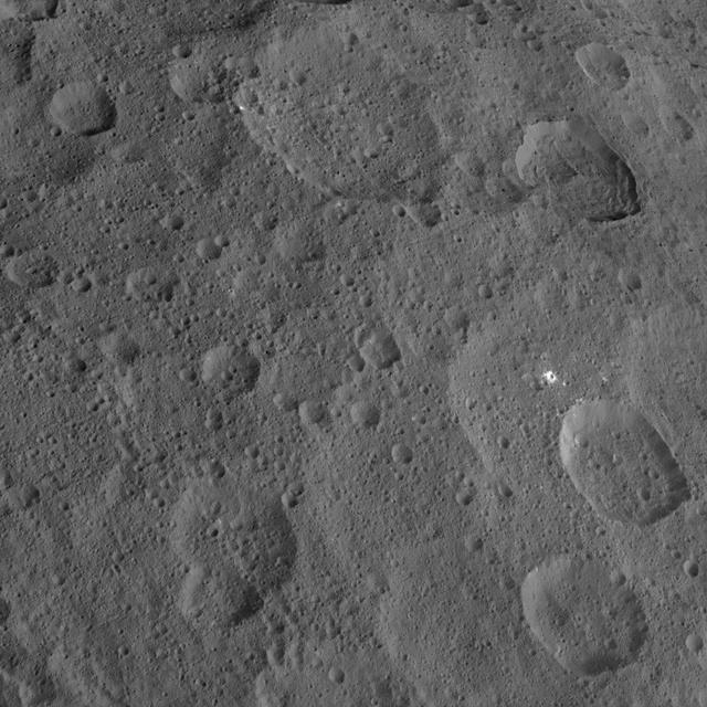 This view, captured on Oct. 18, 2015 from an altitude of 915 miles 1,470 kilometers by NASA Dawn spacecraft, shows northern mid-latitudes on Ceres, including a small impact crater surrounded by bright material. http://photojournal.jpl.nasa.gov/catalog/PIA20140
