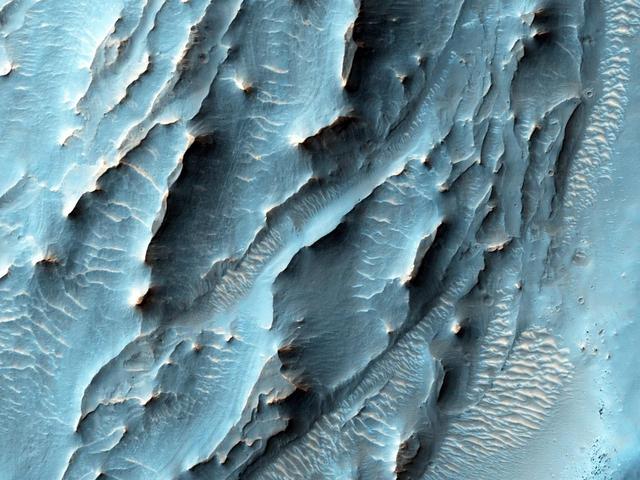 NASA Mars Reconnaissance Orbiter used its HiRISE camera to obtain this view of an area with unusual texture on the southern floor of Gale Crater. An enigmatic deposit appears to have flowed into the small crater from the south.