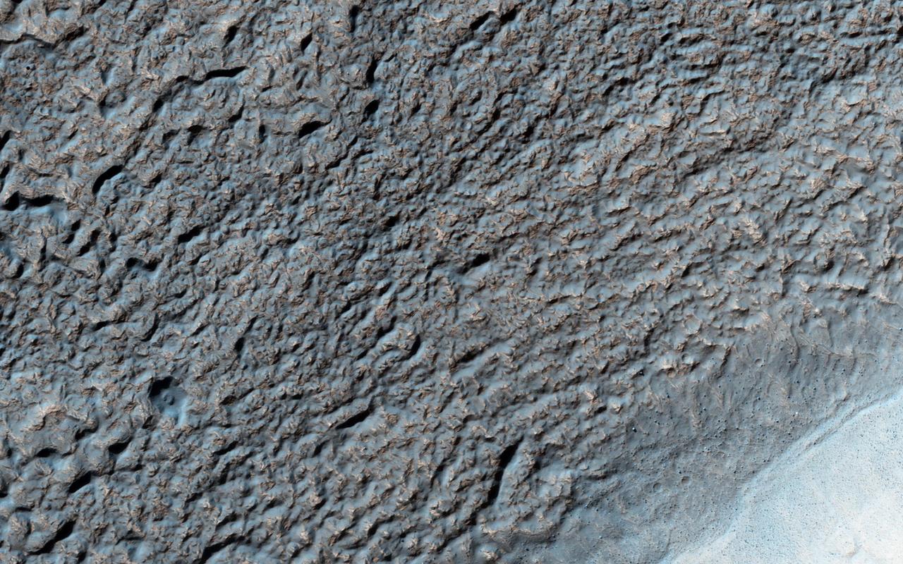 Like Earth's water table, Mars has an ice table. Sometimes, the ice table coincides with the ground's surface as it does here. The knobby, pitted terrain is caused when ice is deposited and then sublimates over and over again. This geologic process is called "accrescence" and "decrescence" and also occurs on Neptune's moon Triton and on Pluto, though in the outer Solar System the ice is not water ice. Other evidence for ice here includes the rope-like, curved flow feature that resembles glacial flow. Solis Planum -- a huge mound south of Valles Marineris -- is the location of this image. http://photojournal.jpl.nasa.gov/catalog/PIA20208