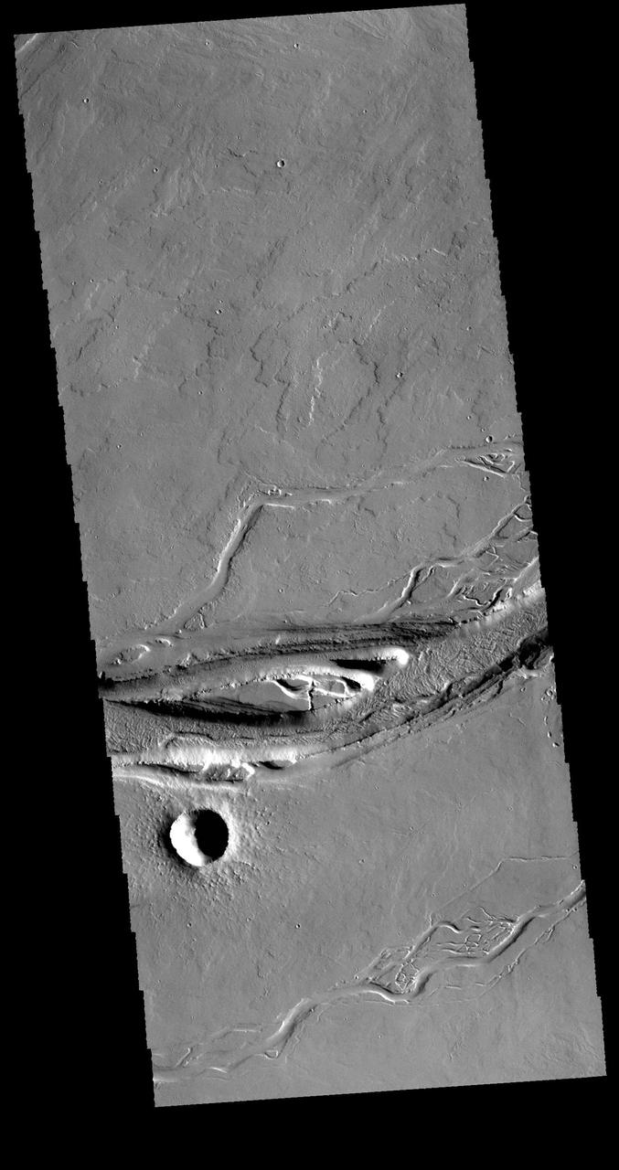 This VIS image shows a portion of Olympica Fossae. In this image several lava channels are visible, and it appears that lava has flowed in the larger depressions. The streamlined feature in the central part of the image also indicates that volcanic processes were active in this region. Orbit Number: 61654 Latitude: 24.8964 Longitude: 246.128 Instrument: VIS Captured: 2015-11-07 08:34. http://photojournal.jpl.nasa.gov/catalog/PIA20222