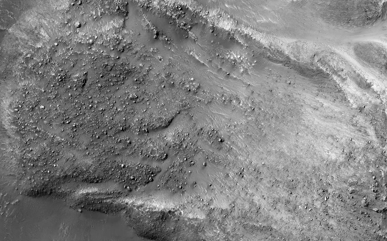 The striking feature in this image from NASA Mars Reconnaissance Orbiter  is a boulder-covered landslide along a canyon wall. Landslides occur when steep slopes fail, sending a mass of soil and rock to flow downhill, leaving behind a scarp at the top of the slope. The mass of material comes to rest when it reaches shallower slopes, forming a lobe of material that ends in a well-defined edge called a toe. http://photojournal.jpl.nasa.gov/catalog/PIA20290