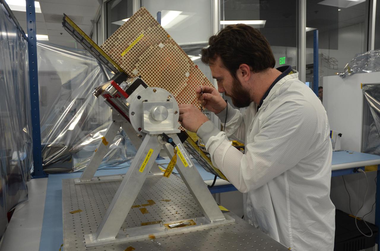 Joel Steinkraus, lead mechanical engineer for the MarCO (Mars Cube One) CubeSat spacecraft, adjusts a model of one of the two spacecraft.  The mock-up in the photo is in a configuration to show the deployed position of components that correspond to MarCO's two solar panels and two antennas. During launch, those components will be stowed for a total vehicle size of about 14.4 inches (36.6 centimeters) by 9.5 inches (24.3 centimeters) by 4.6 inches (11.8 centimeters).  The briefcase-size MarCO twins were designed to ride along with NASA's next Mars lander, InSight. Its planned March 2016 launch was suspended.  InSight -- an acronym for Interior Exploration using Seismic Investigations, Geodesy and Heat Transport -- will study the interior of Mars to improve understanding of the processes that formed and shaped rocky planets, including Earth.  Note: After thorough examination, NASA managers have decided to suspend the planned March 2016 launch of the Interior Exploration using Seismic Investigations Geodesy and Heat Transport (InSight) mission. The decision follows unsuccessful attempts to repair a leak in a section of the prime instrument in the science payload.  http://photojournal.jpl.nasa.gov/catalog/PIA20344