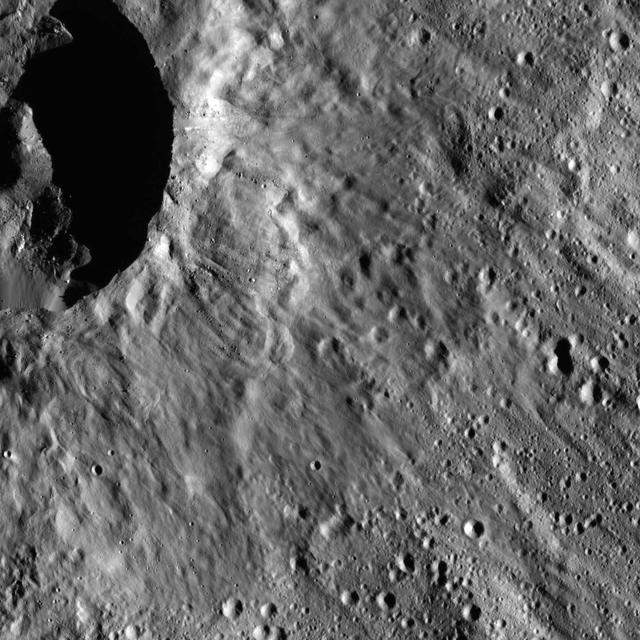 This image from NASA Dawn spacecraft shows a scene located at mid-latitudes in the southern hemisphere of Ceres. The view features a portion of a crater between the large impact features Urvara and Yalode.