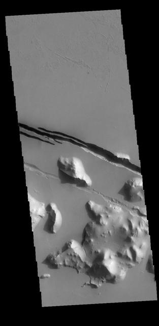 This image captured by NASA 2001 Mars Odyssey spacecraft shows part of Cerberus Fossae. The linear depressions are called fossae.