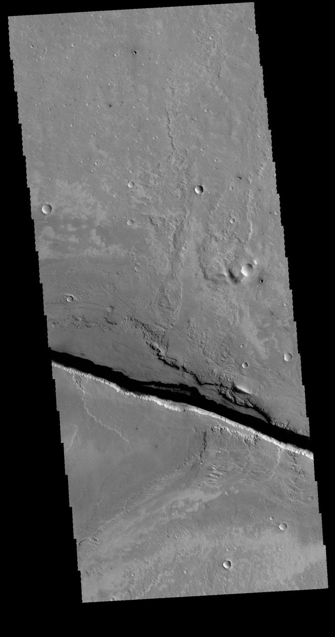 This image captured by NASA 2001 Mars Odyssey spacecraft shows a portion of Cerberus Fossae, a set of linear graben located south of Tartarus Montes.