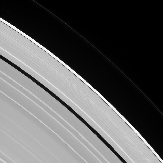 Two tiny moons of Saturn, almost lost amid the planet's enormous rings, are seen orbiting in this image. Pan, visible within the Encke Gap near lower-right, is in the process of overtaking the slower Atlas, visible at upper-left.  All orbiting bodies, large and small, follow the same basic rules. In this case, Pan (17 miles or 28 kilometers across) orbits closer to Saturn than Atlas (19 miles or 30 kilometers across). According to the rules of planetary motion deduced by Johannes Kepler over 400 years ago, Pan orbits the planet faster than Atlas does.  This view looks toward the sunlit side of the rings from about 39 degrees above the ring plane. The image was taken in visible light with the Cassini spacecraft narrow-angle camera on July 9, 2016.  The view was acquired at a distance of approximately 3.4 million miles (5.5 million kilometers) from Atlas and at a Sun-Atlas-spacecraft, or phase, angle of 71 degrees. Image scale is 21 miles (33 kilometers) per pixel.  http://photojournal.jpl.nasa.gov/catalog/PIA20501