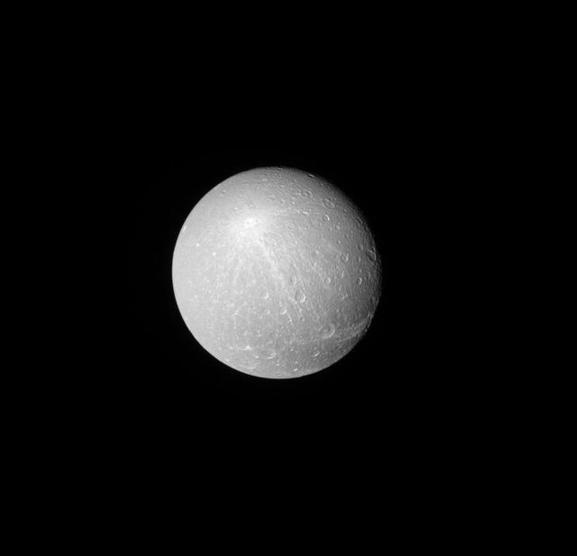 When viewed from a distance with the sun directly behind NASA Cassini, the larger, brighter craters really stand out on moons like Dione. Among these larger craters, some leave bright ray patterns across the moon. The rayed crater seen here on Dione (698 miles, or 1,123 kilometers across) is named Creusa. The rays are brighter material blasted out by the impact that formed the crater. Scientists can use the patterns of ejecta (like these rays), to help determine the order of geological events on a moon's surface by examining which features lie on top of other features. This view looks toward the Saturn-facing side of Dione. North on Dione is up and rotated 31 degrees to the right. The image was taken with the Cassini spacecraft narrow-angle camera on Nov. 26, 2016 using a spectral filter which preferentially admits wavelengths of near-infrared light centered at 727 nanometers. The view was obtained at a distance of approximately 350,000 miles (560,000 kilometers) from Dione. Image scale is 1.8 miles (3 kilometers) per pixel. http://photojournal.jpl.nasa.gov/catalog/PIA20521