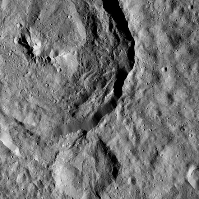 Tupo Crater, named for the Polynesian god of turmeric, is shown at upper left in this view of Ceres from NASA Dawn spacecraft. Just below the crater, a line of narrow troughs parallels the rim of Tupo.