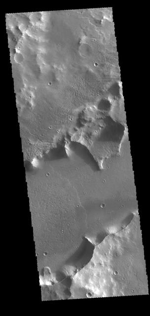 The channel feature in this image from NASA 2001 Mars Odyssey spacecraft is called Mangala Fossa. This feature was formed by tectonic activity, with the walls being faults that allowed the central portion to slide downward forming a graben.