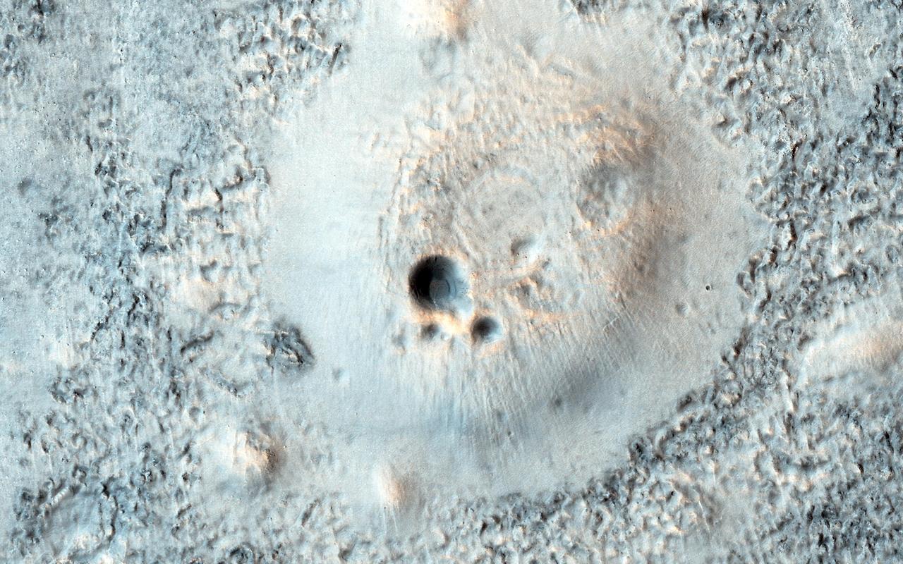 This image from NASA Mars Reconnaissance Orbiter spacecraft shows part of a broad plain covered with cratered cones and domes in the Northern lowlands of Mars.