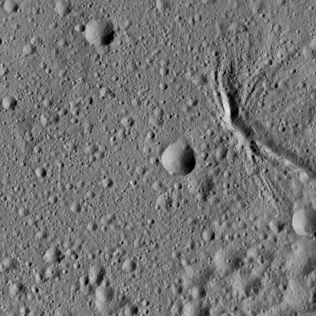 This picture from NASA Dawn spacecraft shows a network of canyon-like features near the center of Ezinu Crater on Ceres. Ezinu measures about 72 miles 116 kilometers in diameter and was named for the Sumerian goddess of grain