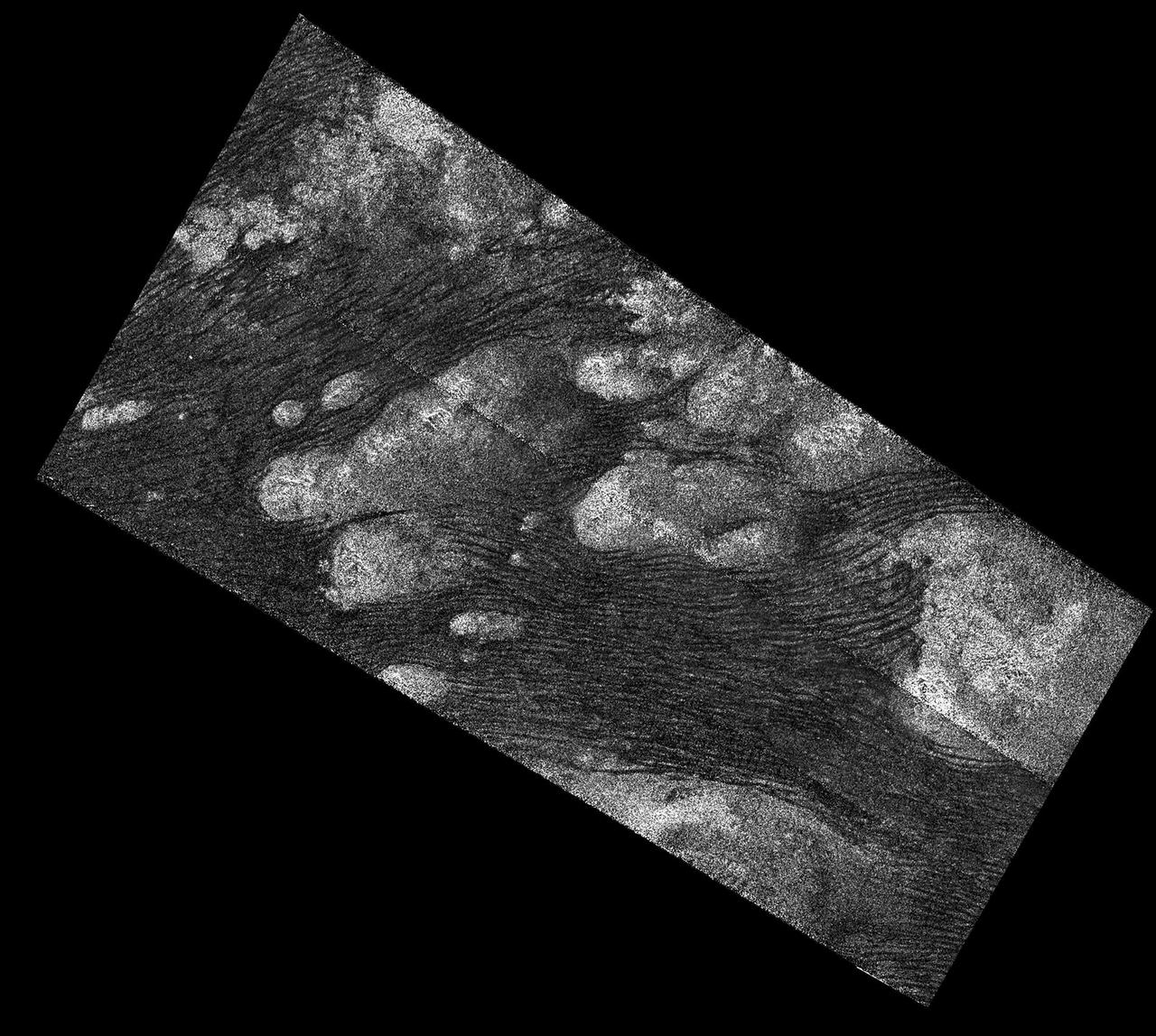 The Shangri-La Sand Sea on Titan is shown in this image from the Synthetic Aperture radar (SAR) on NASA's Cassini spacecraft.   Hundreds of sand dunes are visible as dark lines snaking across the surface. These dunes display patterns of undulation and divergence around elevated mountains (which appear bright to the radar), thereby showing the direction of wind and sand transport on the surface.  Sands being carried from left to right (west to east) cannot surmount the tallest obstacles; instead, they are directed through chutes and canyons between the tall features, evident in thin, blade-like, isolated dunes between bright some features. Once sands have passed around the obstacles, they resume their downwind course, at first collecting into small, patchy dunes and then organizing into larger, more pervasive linear forms, before being halted once again by obstacles.  These patterns reveal the effects not only of wind -- perhaps even modern winds if the dunes are actively moving today -- but also the effects of underlying bedrock and surrounding topography.  Dunes across the solar system aid in our understanding of underlying topography, winds and climate, past and present. Similar patterns can be seen in dunes of the Great Sandy Desert in Australia, where dunes undulate broadly across the uneven terrain and are halted at the margins of sand-trapping lakes. The dune orientations correlate generally with the direction of current trade winds, and reveal that winds must have been similar back when the dunes formed, during the Pleistocene glacial and interglacial periods.  An annotated version of this radar image is also available.at the Photojournal. North on Titan is up in the image. Radar illuminates the scene from upper right at a 27-degree incidence angle.  http://photojournal.jpl.nasa.gov/catalog/PIA20710