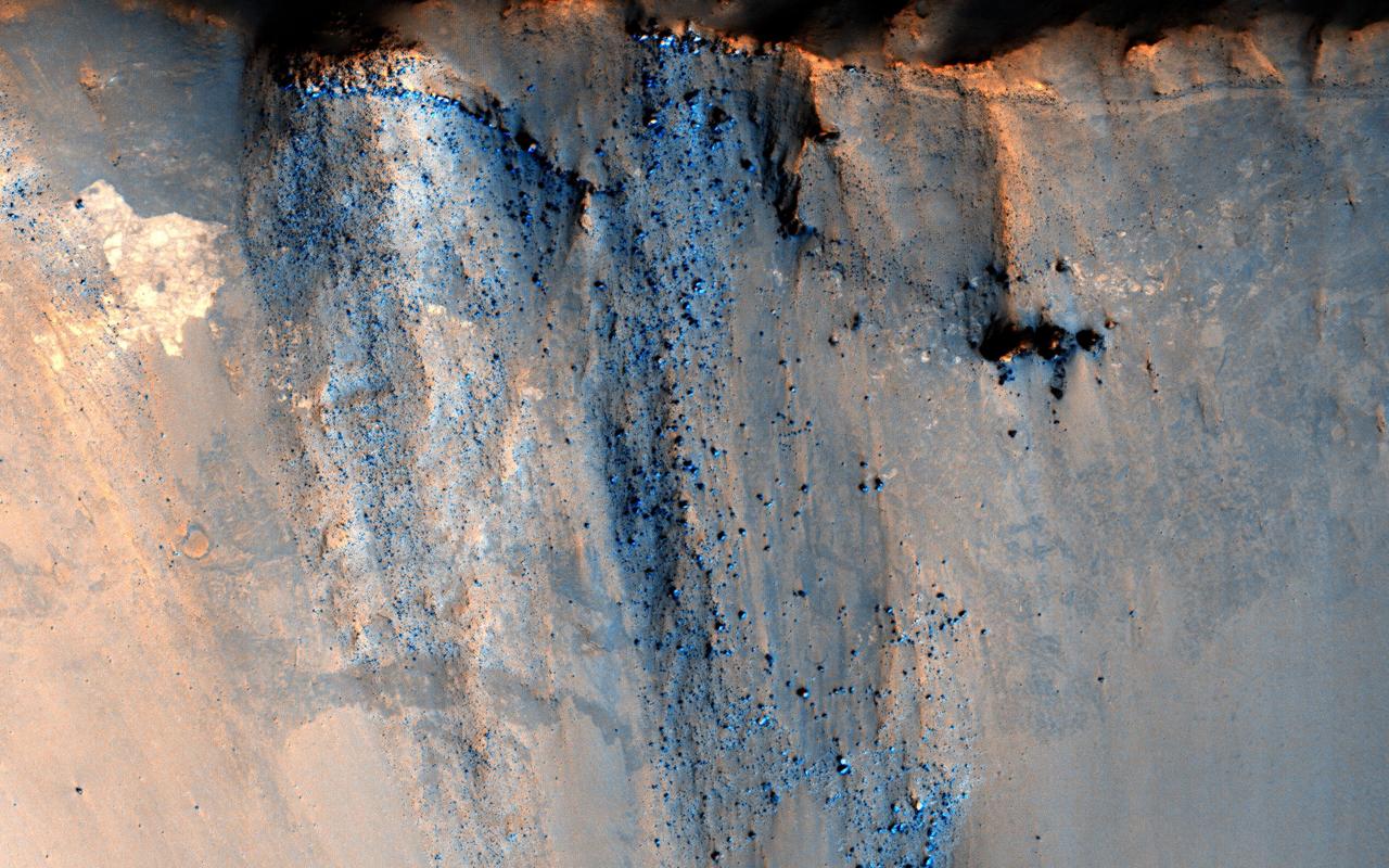 This image captured by NASA Mars Reconnaissance Orbiter spacecraft targets a 3-kilometer diameter crater that occurs within the ejecta blanket of the much older Bakhuysen Crater, a 150-kilometer diameter impact crater in Noachis Terra.  Impact craters are interesting because they provide a mechanism to uplift and expose underlying bedrock, allowing for the study of the subsurface and the geologic past. An enhanced color image shows the wall of the crater, which exposes layering as well as blocks of rock. There is a distinctive large block in the upper left of the crater wall, generally referred to as a "mega-block."Â It is an angular, light-toned, highly fragmented block, about 100 meters across. Several smaller light-toned blocks are also in the crater wall, possibly of the same rock type as the "mega-block."  Ejecta blocks are thrown outward during the initial excavation of a crater, or are deposited as part of the ground-hugging flows of which the majority of the ejecta blanket is comprised. Through images like these, we are able to study the deeper subsurface of Mars that is not otherwise exposed.   http://photojournal.jpl.nasa.gov/catalog/PIA20728