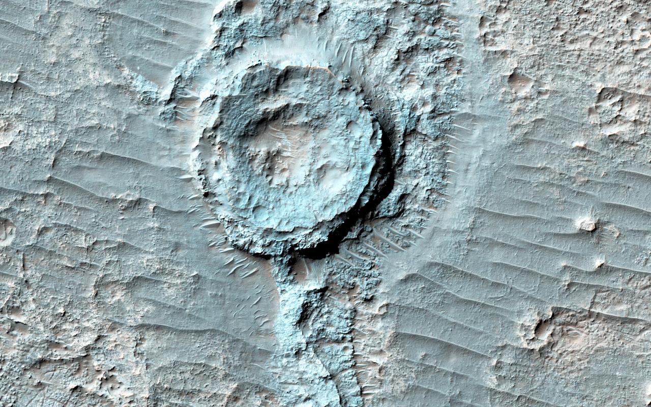 There is a circular feature in this observation from NASA Mars Reconnaissance Orbiter spacecraft that appears to stand above the surrounding terrain. This feature is probably an inverted crater that was filled in with sediment. The fill became indurated, or hardened, until it was more resistant to subsequent erosion than the surrounding material. Other craters in this image are not inverted or substantially infilled. This suggests that they were formed after the events that filled in and later exposed the inverted crater. http://photojournal.jpl.nasa.gov/catalog/PIA20729