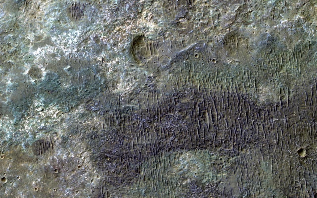 This image from NASA Mars Reconnaissance Orbiter spacecraft covers some of the plains south of Capri Chasma in eastern Valles Marineris. Where the aeolian (wind-blown) sedimentary cover has been stripped away, we see diverse colors indicative of of a variety of altered minerals formed in Mars' wetter past. http://photojournal.jpl.nasa.gov/catalog/PIA20730