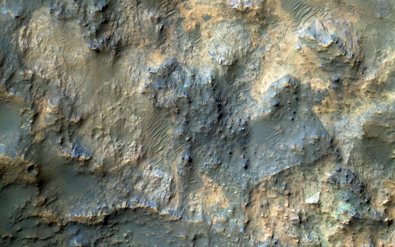 This image samples the excellent bedrock exposures north of Terby Crater, which lies on the northern rim of the giant Hellas basin.  An enhanced-color cutout shows a sample of this bedrock, which has a variety of colors and textures. The warm-colored bedrock probably contains hydrated minerals such as clays, whereas the blue-green bedrock is dominated by unaltered mafic minerals. These may be some of the oldest rocks exposed at the Martian surface. Such ancient rocks are extremely rare on Earth.   http://photojournal.jpl.nasa.gov/catalog/PIA20737