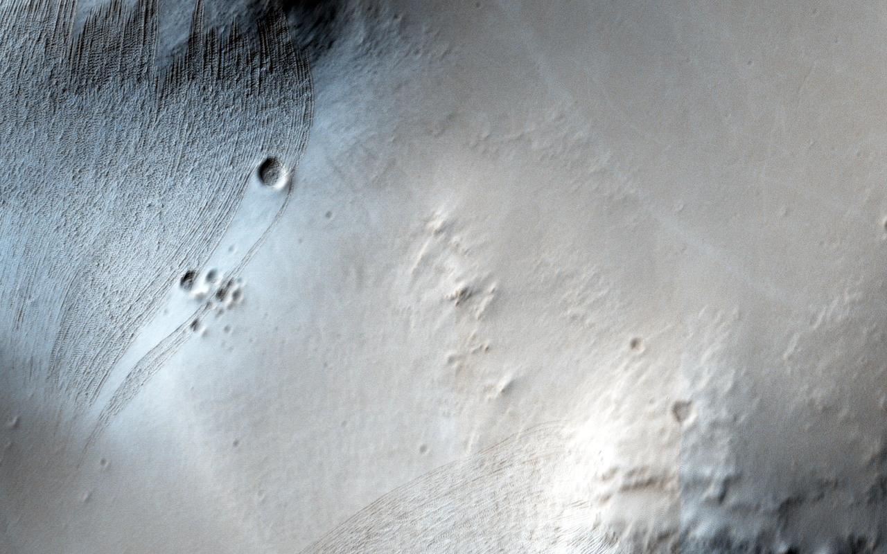 Noctis Labyrinthus is a highly tectonized region immediately to the west of Valles Marineris. It formed when Mars' crust stretched itself apart. In this region, the crust first stretched in a north-south direction (as evidenced by the east-west trending scarp) and then in an east-west direction (as evidenced by the north-south trending smaller scarps). This sort of tectonic stretching creates faults in the crust (cracks along with masses of rock slide. This process is totally unrelated to Earth's plate tectonics.). The lower portions between faults are called "grabens" and the interspersed higher portions are called "horsts." The Basin and Range tectonic province of the western United States is a close Earth analog to Noctis Labyrinthus, which is Latin for "labyrinth of the night." http://photojournal.jpl.nasa.gov/catalog/PIA20740