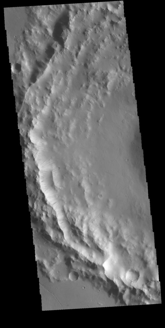 This image captured by NASA 2001 Mars Odyssey spacecraft shows the inner rim of an unnamed crater on the western margin of Daedalia Planum. Numerous dark streaks are visible on the faces of the inner rim. A possible mode of formation of these features is the down slope movement of a block/rock that disturbs the surface dust revealing the darker rock beneath. Orbit Number: 63851 Latitude: -11.9984 Longitude: 213.542 Instrument: VIS Captured: 2016-05-06 07:05 http://photojournal.jpl.nasa.gov/catalog/PIA20775
