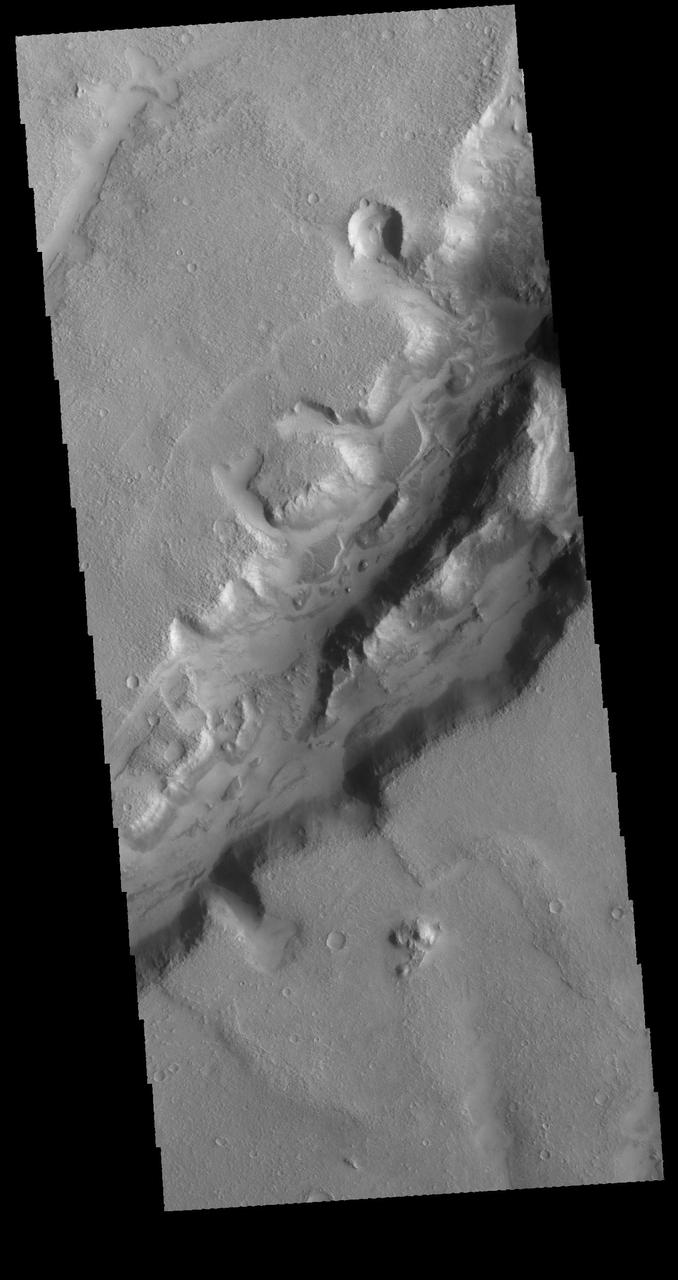 Nili Fossae is a large band of parallel graben located to the northeast of Syrtis Major. The graben in this image from NASA 2001 Mars Odyssey spacecraft were formed by tectonic activity, with faulting that creates the linear depression. Orbit Number: 64105 Latitude: 23.3115 Longitude: 78.6126 Instrument: VIS Captured: 2016-05-27 05:24 http://photojournal.jpl.nasa.gov/catalog/PIA20785