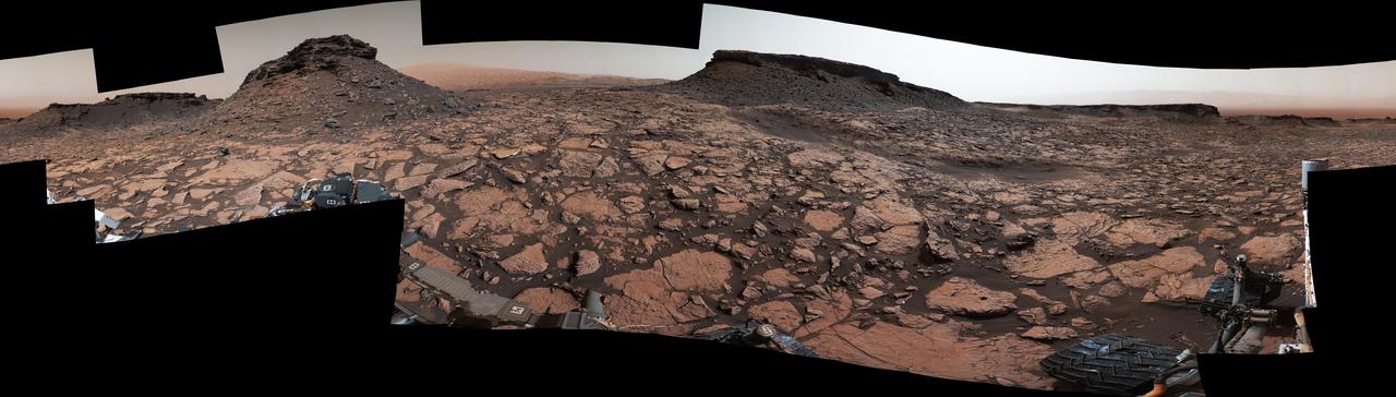 Original Caption Released with Image:      This 360-degree panorama was acquired by the Mast Camera (Mastcam) on NASA's Curiosity Mars rover while the rover was in an area called "Murray Buttes" on lower Mount Sharp, one of the most scenic landscapes yet visited by any Mars rover.      The view stitches together many individual images taken by Mastcam's left-eye camera on Sept. 4, 2016, during the 1,451st Martian day, or sol, of the mission. North is at both ends and south is in the center. The rover's location when it recorded this scene was the site it reached in its Sol 1448 drive. (See map at http://mars.nasa.gov/msl/multimedia/images/?ImageID=8015.)      The dark, flat-topped mesa near the center of the scene rises to about 39 feet (about 12 meters) above the surrounding plain. From the rover's position, the top of this mesa is about 131 feet (about 40 meters) away, and the beginning of the debris apron at the base of the mesa is about 98 feet (about 30 meters) away.      In the left half of the image, the dark butte that appears largest sits eastward from the rover and about 33 feet (about 10 meters) high. From the rover's position, the top of this butte is about 85 feet (about 26 meters) away, and the beginning of the debris apron at its base is about 33 feet (about 10 meters) away. An upper portion of Mount Sharp appears on the horizon to the right of it.      The relatively flat foreground is part of a geological layer called the Murray formation, which includes lakebed mud deposits. The buttes and mesas rising above this surface are eroded remnants of ancient sandstone that originated when winds deposited sand after lower Mount Sharp had formed. They are capped by material that is relatively resistant to erosion, just as is the case with many similarly shaped buttes and mesas on Earth. The area's informal naming honors Bruce Murray (1931-2013), a Caltech planetary scientist and director of NASA's Jet Propulsion Laboratory, Pasadena, California.      The scene is presented with a color adjustment that approximates white balancing, to resemble how the rocks and sand would appear under daytime lighting conditions on Earth.   http://photojournal.jpl.nasa.gov/catalog/PIA20840