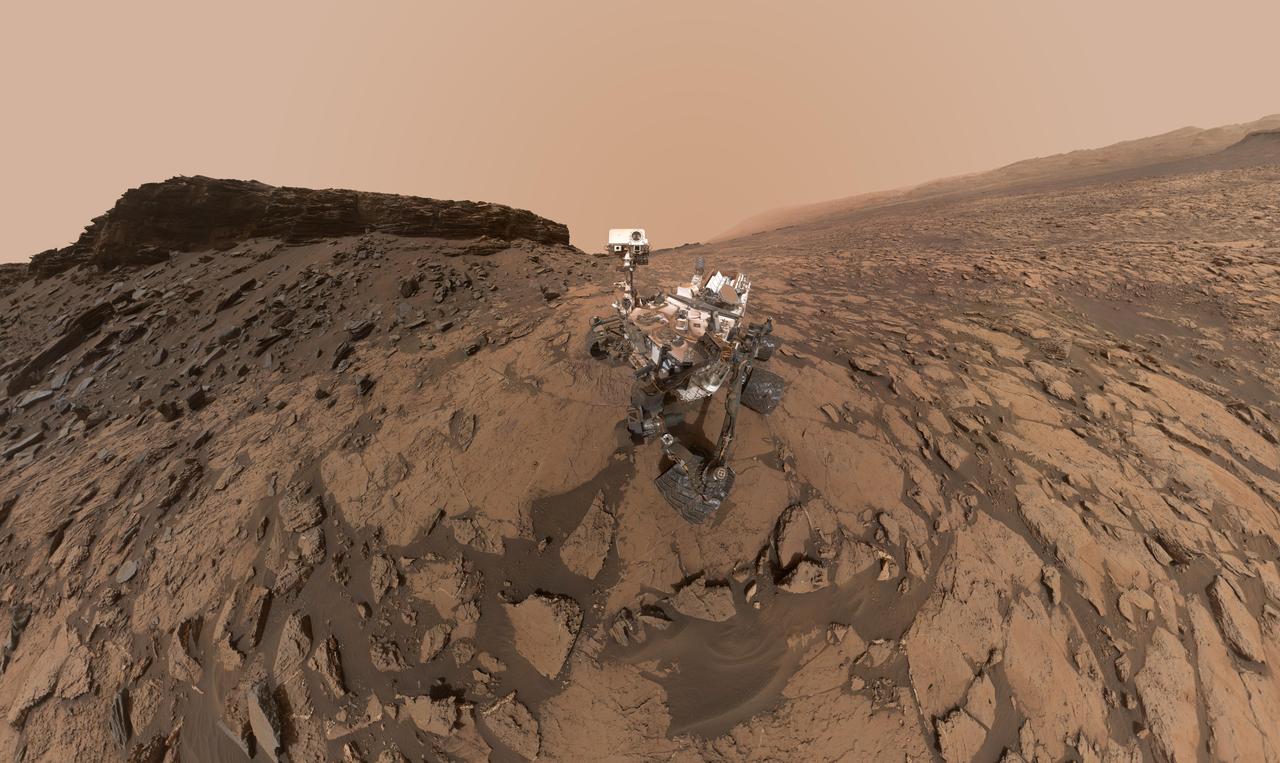 This self-portrait of NASA's Curiosity Mars rover shows the vehicle at the "Quela" drilling location in the "Murray Buttes" area on lower Mount Sharp.  Key features on the skyline of this panorama are the dark mesa called "M12" to the left of the rover's mast and pale, upper Mount Sharp to the right of the mast. The top of M12 stands about 23 feet (7 meters) above the base of the sloping piles of rocks just behind Curiosity.  The scene combines approximately 60 images taken by the Mars Hand Lens Imager (MAHLI) camera at the end of the rover's robotic arm. Most of the component images were taken on Sept. 17, 2016, during the 1,463rd Martian day, or sol, of Curiosity's work on Mars. Two component images of the drill-hole area in front of the rover were taken on Sol 1466 (Sept. 20) to show the hole created by collecting a drilled sample at Quela on Sol 1464 (Sept. 18).  The skyline sweeps from west on the left to south-southwest on the right, with the rover's mast at northeast. The rover's location when it recorded this scene was where it ended a drive on Sol 1455, mapped at http://mars.nasa.gov/msl/multimedia/images/?ImageID=8029.  The view does not include the rover's arm nor the MAHLI camera itself, except in the miniature scene reflected upside down in the parabolic mirror at the top of the mast. That mirror is part of Curiosity's Chemistry and Camera (ChemCam) instrument. MAHLI appears in the center of the mirror.  Wrist motions and turret rotations on the arm allowed MAHLI to acquire the mosaic's component images. The arm was positioned out of the shot in the images, or portions of images, that were used in this mosaic. This process was used previously in acquiring and assembling Curiosity self-portraits taken at other sample-collection sites, including "Rocknest" (PIA16468), "Windjana" (PIA18390"), "Buckskin" (PIA19808) and "Gobabeb" (PIA20316).  For scale, the rover's wheels are 20 inches (50 centimeters) in diameter and about 16 inches (40 centimeters) wide.   http://photojournal.jpl.nasa.gov/catalog/PIA20844