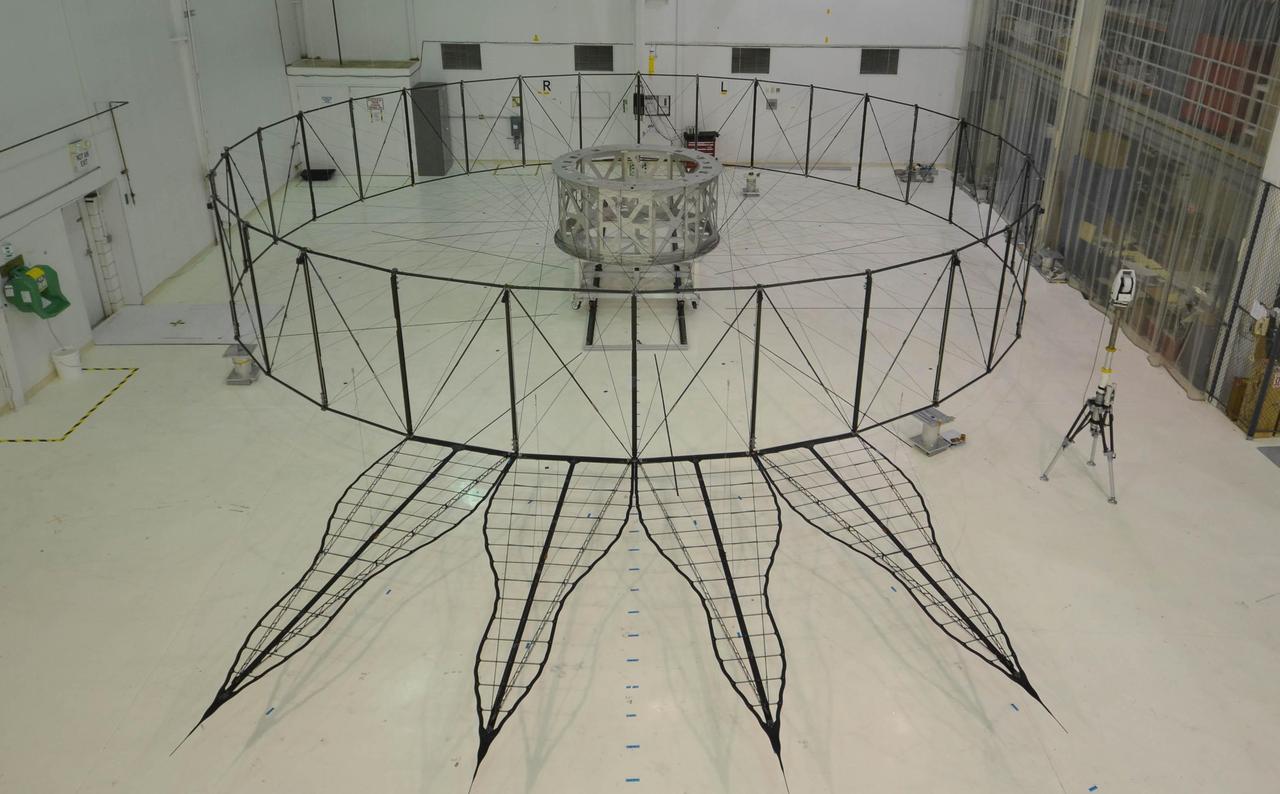 This image shows the bare bones of the first prototype starshade by NASA's Jet Propulsion Laboratory, Pasadena, California. The prototype was shown in technology partner Astro Aerospace/Northrup Grumman's facility in Santa Barbara, California in 2013. In order for the petals of the starshade to diffract starlight away from the camera of a space telescope, they must be deployed with accuracy once the starshade reaches space.  The four petals pictured in the image are being measured for this positional accuracy with a laser. As shown by this 66-foot (20-meter) model, starshades can come in many shapes and sizes. This design shows petals that are more extreme in shape which properly diffracts starlight for smaller telescopes.   http://photojournal.jpl.nasa.gov/catalog/PIA20903
