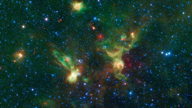 Just in time for the 50th anniversary of the TV series "Star Trek," which first aired September 8th,1966, this infrared image from NASA's Spitzer Space Telescope may remind fans of the historic show. Just as one might see the shapes of animals or other objects in clouds -- a phenomenon called pareidolia -- iconic starships from the series may seem to emerge in these nebulae./  With a little scrutiny (see Figure 1), you may see hints of the saucer and hull of the original USS Enterprise, captained by James T. Kirk, as if it were emerging from a dark nebula. To the left, its "Next Generation" successor, Jean-Luc Picard's Enterprise-D, flies off in the opposite direction.  Astronomically speaking, the region pictured here falls within the disk of our Milky Way galaxy, and displays two regions of star formation that are hidden behind a haze of dust when viewed in visible light. Spitzer's ability to peer deeper into dust clouds has revealed a myriad of stellar birthplaces like these, which are officially known only by their catalog numbers, IRAS 19340+2016 and IRAS19343+2026.  Trekkies, however, may prefer using the more familiar designations NCC-1701 and NCC-1701-D.  This image was assembled using data from Spitzer's biggest surveys of the Milky Way, called GLIMPSE and MIPSGAL. Light with a wavelength of 3.5 microns is shown in blue, 8.0 microns is green, and 24 microns in red. The green colors highlight organic molecules in the dust clouds, illuminated by starlight. Red colors are related to thermal radiation emitted from the very hottest areas of dust.  http://photojournal.jpl.nasa.gov/catalog/PIA20917