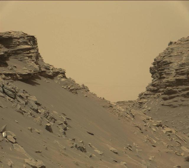 This view from the Mast Camera (Mastcam) in NASA's Curiosity Mars rover shows sloping buttes and layered outcrops within the "Murray Buttes" region on lower Mount Sharp. The buttes and mesas rising above the surface are eroded remnants of ancient sandstone that originated when winds deposited sand after lower Mount Sharp had formed. Curiosity closely examined that layer -- called the "Stimson formation" -- during the first half of 2016, while crossing a feature called "Naukluft Plateau" between two exposures of the Murray formation. The layering within the sandstone is called "cross-bedding" and indicates that the sandstone was deposited by wind as migrating sand dunes. The image was taken on Sept. 8, 2016, during the 1454th Martian day, or sol, of Curiosity's work on Mars. http://photojournal.jpl.nasa.gov/catalog/PIA21042