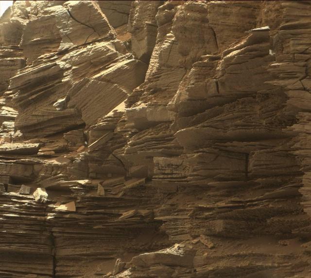 This view from the Mast Camera (Mastcam) in NASA's Curiosity Mars rover shows finely layered rocks within the "Murray Buttes" region on lower Mount Sharp.  The buttes and mesas rising above the surface in this area are eroded remnants of ancient sandstone that originated when winds deposited sand after lower Mount Sharp had formed. Curiosity closely examined that layer -- called the "Stimson formation" -- during the first half of 2016, while crossing a feature called "Naukluft Plateau" between two exposures of the Murray formation. The layering within the sandstone is called "cross-bedding" and indicates that the sandstone was deposited by wind as migrating sand dunes.  The image was taken on Sept. 8, 2016, during the 1454th Martian day, or sol, of Curiosity's work on Mars.   http://photojournal.jpl.nasa.gov/catalog/PIA21043