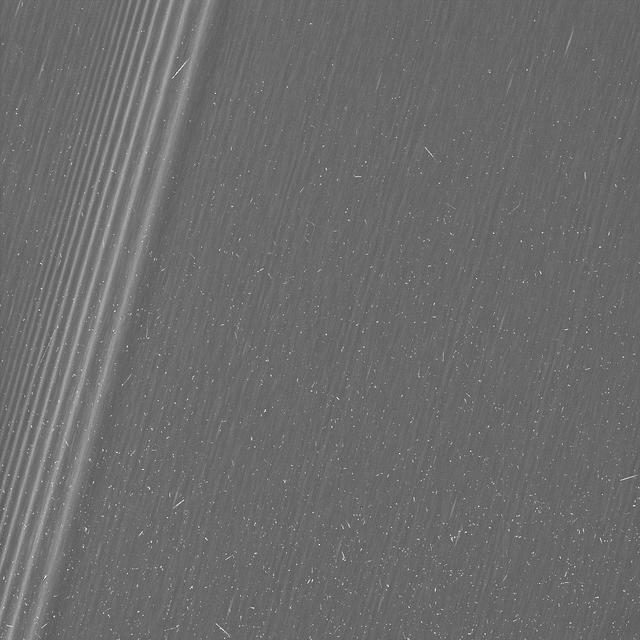 This image from NASA's Cassini mission shows a region in Saturn's A ring. The level of detail is twice as high as this part of the rings has ever been seen before. The view contains many small, bright blemishes due to cosmic rays and charged particle radiation near the planet.  The view shows a section of the A ring known to researchers for hosting belts of propellers -- bright, narrow, propeller-shaped disturbances in the ring produced by the gravity of unseen embedded moonlets. Several small propellers are visible in this view. These are on the order of 10 times smaller than the large, bright propellers whose orbits scientists have routinely tracked (and which are given nicknames for famous aviators).  This image is a lightly processed version, with minimal enhancement, preserving all original details present in the image.  he image was taken in visible light with the Cassini spacecraft wide-angle camera on Dec. 18, 2016. The view was obtained at a distance of approximately 33,000 miles (54,000 kilometers) from the rings and looks toward the unilluminated side of the rings. Image scale is about a quarter-mile (330 meters) per pixel.  http://photojournal.jpl.nasa.gov/catalog/PIA21059