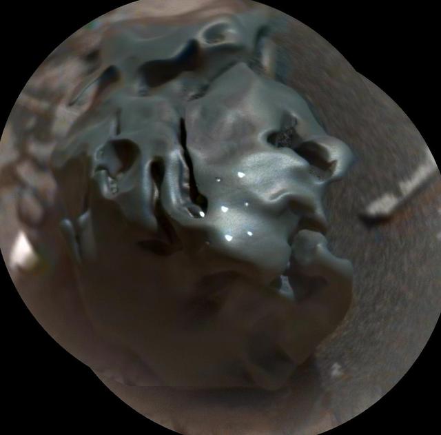 The dark, golf-ball-size object in this composite, colorized view from the Chemistry and Camera (ChemCam) instrument on NASA's Curiosity Mars rover shows a grid of shiny dots where ChemCam had fired laser pulses used for determining the chemical elements in the target's composition.  The analysis confirmed that this object, informally named "Egg Rock," is an iron-nickel meteorite. Iron-nickel meteorites are a common class of space rocks found on Earth, and previous examples have been found on Mars, but Egg Rock is the first on Mars to be examined with a laser-firing spectrometer.  The laser pulses on Oct. 30, 2016, induced bursts of glowing gas at the target, and ChemCam's spectrometer read the wavelengths of light from those bursts to gain information about the target's composition. The laser pulses also burned through the dark outer surface, exposing bright interior material. This view combines two images taken later the same day by ChemCam's remote micro-imager (RMI) camera, with color added from an image taken by Curiosity's Mast Camera (Mastcam). A Mastcam image of Egg Rock is at PIA21134.  http://photojournal.jpl.nasa.gov/catalog/PIA21133