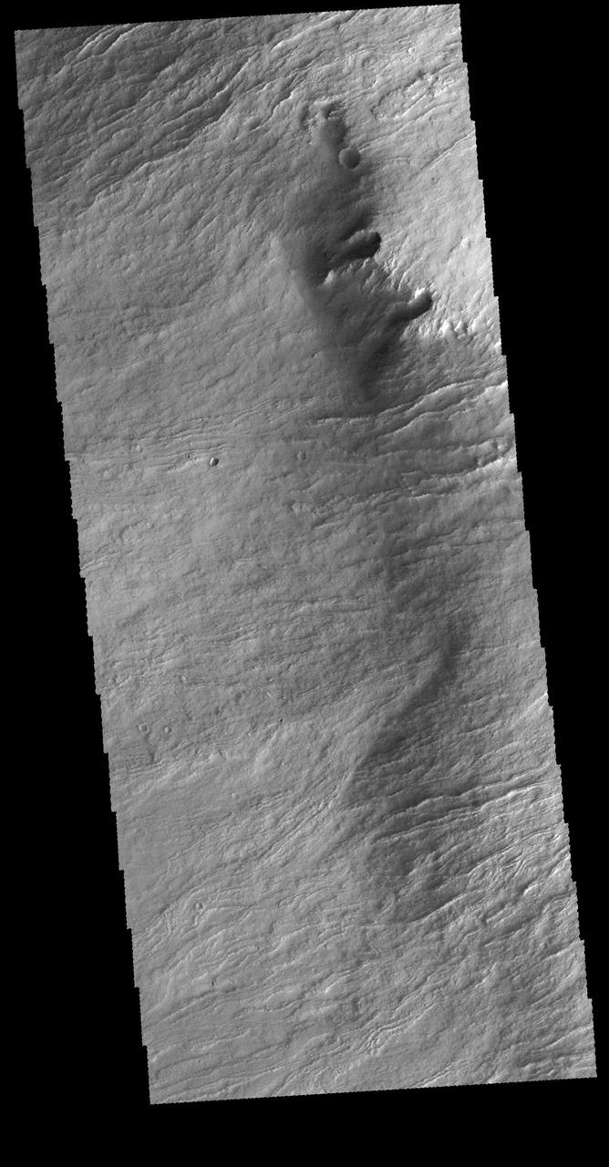 The margin of Olympus Mons consists of a cliff-like edge where elevation changes very quickly over a very small width. This edge is called Olympus Rupes. This VIS image shows part of that edge and the lava flows that spilled over the edge to flood the surrounding plains.  Orbit Number: 65335 Latitude: 16.0811 Longitude: 221.373 Instrument: VIS Captured: 2016-09-05 12:58  http://photojournal.jpl.nasa.gov/catalog/PIA21155