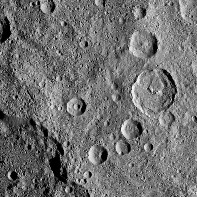 In this densely cratered area of Ceres, NASA's Dawn spacecraft spotted Tupo Crater, with its complex, hummocky interior, at center right. A portion of the rim of Darzamat Crater appears with dark shadows at lower left. Dawn took this image on Oct. 19 from its second extended-mission science orbit (XMO2), at a distance of about 920 miles (1,480 kilometers) above the surface. The image resolution is about 460 feet (140 meters) per pixel. http://photojournal.jpl.nasa.gov/catalog/PIA21233
