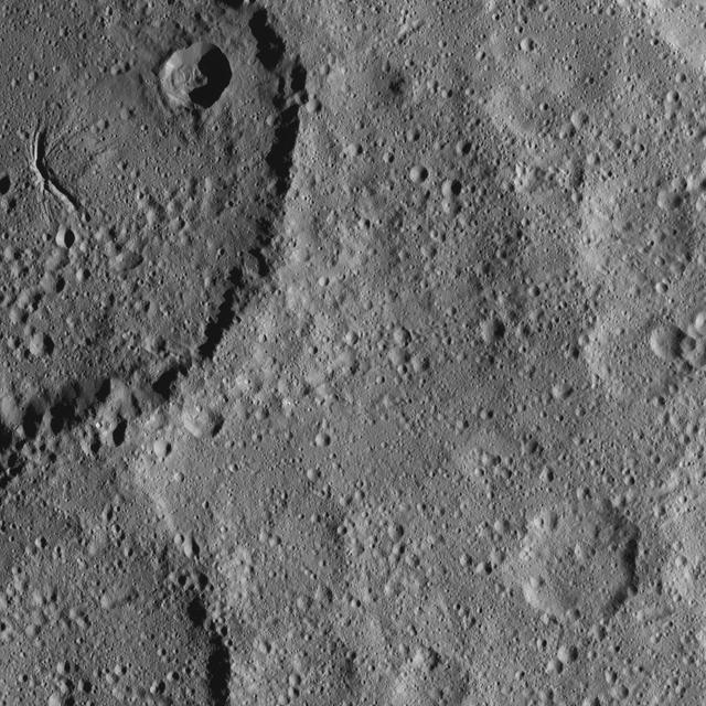 Part of Ezinu Crater on Ceres is seen at top left in this image from NASA's Dawn spacecraft. The crater features a network of canyon-like features. Ezinu measures about 72 miles (116 kilometers) in diameter and was named for the Sumerian goddess of grain. Dawn took this image on Oct. 20, 2016, from its second extended-mission science orbit (XMO2), at a distance of about 920 miles (1,480 kilometers) above the surface. The image resolution is about 460 feet (140 meters) per pixel. http://photojournal.jpl.nasa.gov/catalog/PIA21239
