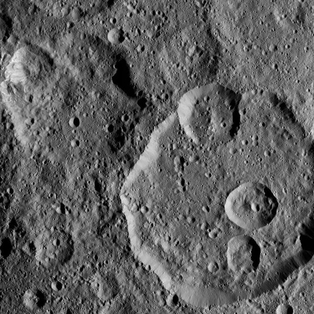 Meanderi Crater on Ceres is seen at lower right in this image from NASA's Dawn spacecraft. Meanderi -- named for the Ngaing goddess (New Guinea) of taro, sugar cane and other foods -- hosts several medium-sized craters within its walls. Meanderi measures 64 miles (103 kilometers) in diameter. The crater is centered at 41 degrees south, 194 degrees east. Dawn took this image on Oct. 26, 2016, during its second extended-mission science orbit (XMO2), from a distance of about 920 miles (1,480 kilometers) above the surface of Ceres. The image resolution is about 460 feet (140 meters) per pixel. http://photojournal.jpl.nasa.gov/catalog/PIA21248