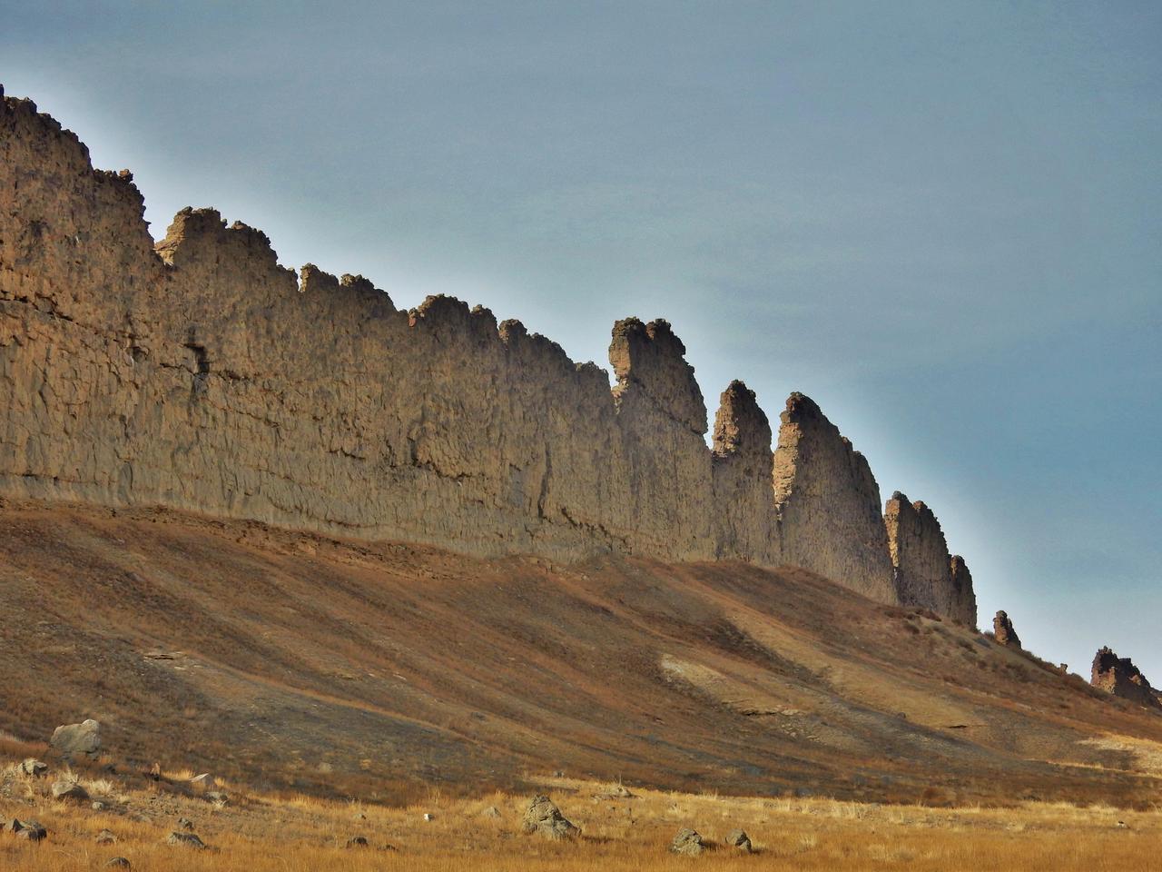 This photograph from northwestern New Mexico shows a ridge roughly 30 feet about 10 meters tall that formed from lava filling an underground fracture then resisting erosion better than the material around it did.  The dike extends from a volcanic peak (out of view here) called Shiprock in English and Tsé Bit'a'í, meaning "rock with wings," in the Navajo language. It offers an Earth analog for some larger hardened-lava walls on Mars  http://photojournal.jpl.nasa.gov/catalog/PIA21266
