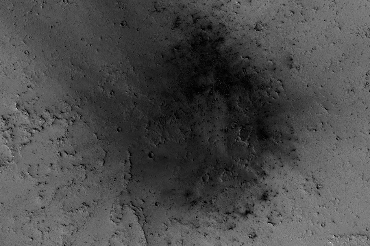 NASA's Mars Reconnaissance Orbiter has been observing Mars in sharp detail for more than a decade, enabling it to document many types of changes, such as the way winds alter the appearance of this recent impact site.  The space-rock impact that created this blast zone occurred sometime between September 2005 and February 2006, as bracketed by observations made with the Mars Orbiter Camera on NASA's Mars Global Surveyor spacecraft. The location is between two large volcanos, named Ascraeus Mons and Pavonis Mons, in a dusty area of the Tharsis region of Mars. During the period from 2007 to 2012, winds blowing through the pass between the volcanoes darkened some regions and brightened others, probably by removing and depositing dust.   The view covers an area about 1.0 mile (1.6 kilometers) across, at 7 degrees north latitude, 248 degrees east longitude. North is toward the top.  An animation is availalble at http://photojournal.jpl.nasa.gov/catalog/PIA21267