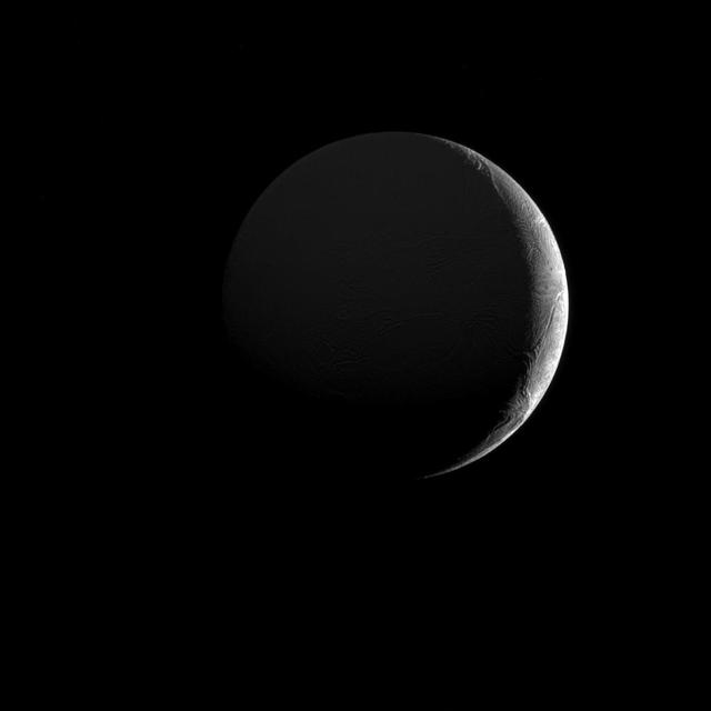 The low angle of sunlight along the slim crescent of Saturn's moon Enceladus (313 miles or 504 kilometers across) highlights the many fractures and furrows on its icy surface.  This view looks toward the Saturn-facing hemisphere of Enceladus, which is dimly illuminated in the image above by sunlight reflected off Saturn. North on Enceladus is up and rotated 14 degrees to the left. The image was taken in visible light with NASA's Cassini spacecraft narrow-angle camera on Dec. 26, 2016.  The view was obtained at a distance of approximately 104,000 miles (168,000 kilometers) from Enceladus. Image scale is 3,303 feet (1 kilometer) per pixel.  https://photojournal.jpl.nasa.gov/catalog/PIA21330