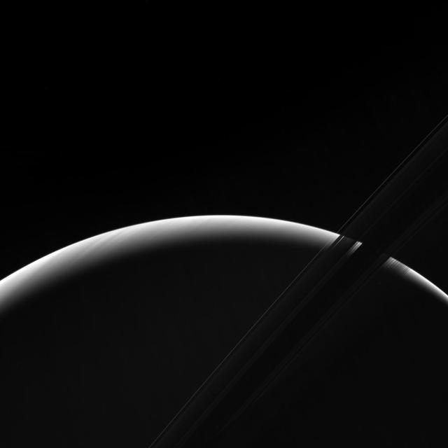 NASA's Cassini spacecraft peers toward a sliver of Saturn's sunlit atmosphere while the icy rings stretch across the foreground as a dark band. This view looks toward the unilluminated side of the rings from about 7 degrees below the ring plane. The image was taken in green light with the Cassini spacecraft wide-angle camera on March 31, 2017. The view was obtained at a distance of approximately 620,000 miles (1 million kilometers) from Saturn. Image scale is 38 miles (61 kilometers) per pixel. https://photojournal.jpl.nasa.gov/catalog/PIA21334