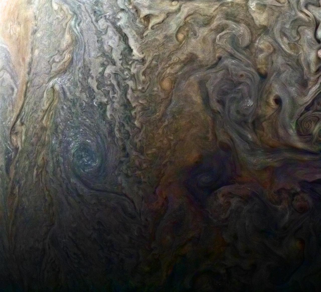 This enhanced-color image of a mysterious dark spot on Jupiter seems to reveal a Jovian "galaxy" of swirling storms. Juno acquired this JunoCam image on Feb. 2, 2017, at 5:13 a.m. PDT (8:13 a.m. EDT), at an altitude of 9,000 miles (14,500 kilometers) above the giant planet's cloud tops. This publicly selected target was simply titled "Dark Spot." In ground-based images it was difficult to tell that it is a dark storm. Citizen scientist Roman Tkachenko enhanced the color to bring out the rich detail in the storm and surrounding clouds. Just south of the dark storm is a bright, oval-shaped storm with high, bright, white clouds, reminiscent of a swirling galaxy. As a final touch, he rotated the image 90 degrees, turning the picture into a work of art. http://photojournal.jpl.nasa.gov/catalog/PIA21386 . - Enhanced image by Roman Tkachenko (CC-BY) based on images provided courtesy of NASA/JPL-Caltech/SwRI/MSSS
